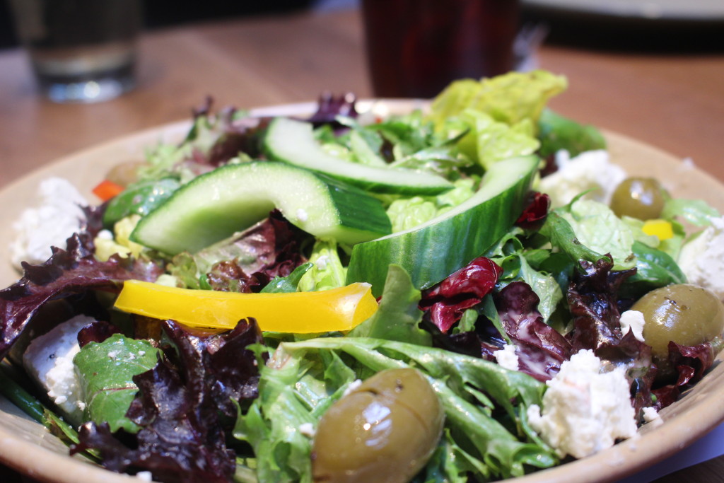 Mixed salad greens with peppers, tomatoes, cucumber, feta cheese and olives.